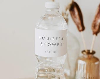 Könnte beinhalten: Eine weiße Wasserflasche mit einem weißen Etikett, auf dem "LOUISE'S SHOWER 07.21.20XX" steht.