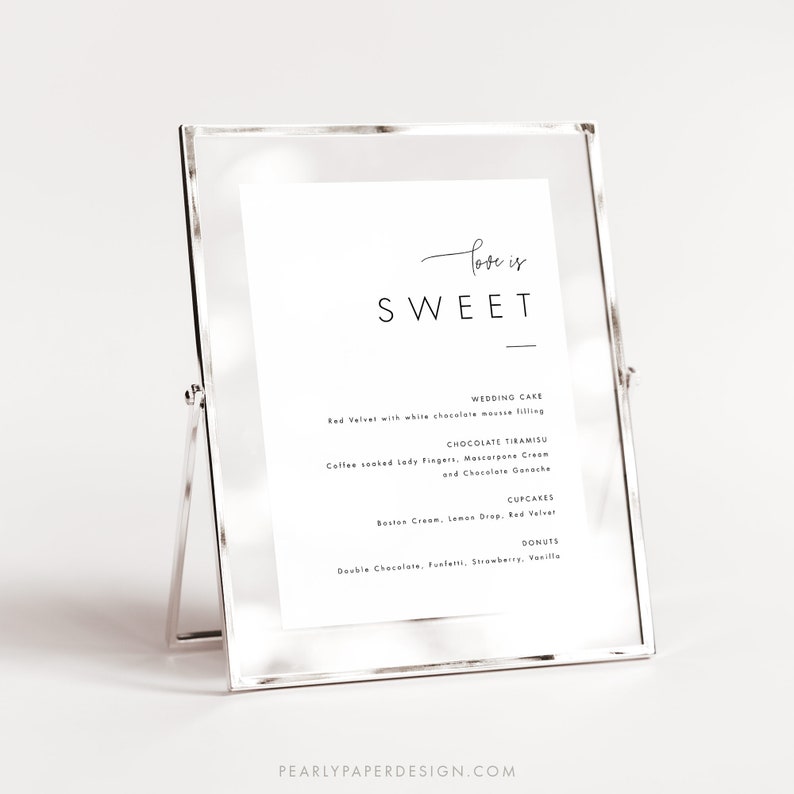 Puede incluir: Un cartel enmarcado en plata con el texto "Love is Sweet" en la parte superior. El cartel enumera varias opciones de postres, que incluyen pastel de bodas, tiramis&uacute; de chocolate, cupcakes y donas.
