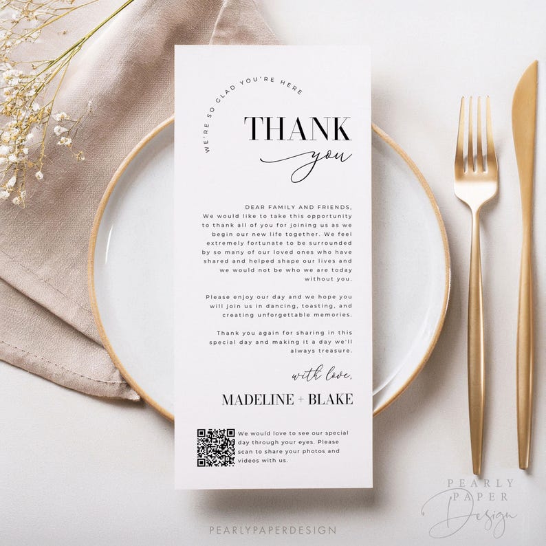 Op de afbeelding: Een witte bedankkaart met zwarte tekst. De kaart zegt "We're so glad you're here" in een cirkel bovenaan. De tekst "Thank you" staat in een groot lettertype met een handgeschreven "you". De kaart bevat ook een QR-code en de tekst "We would love to see our special day through your eyes. Please scan to share your photos and videos with us." onderaan.