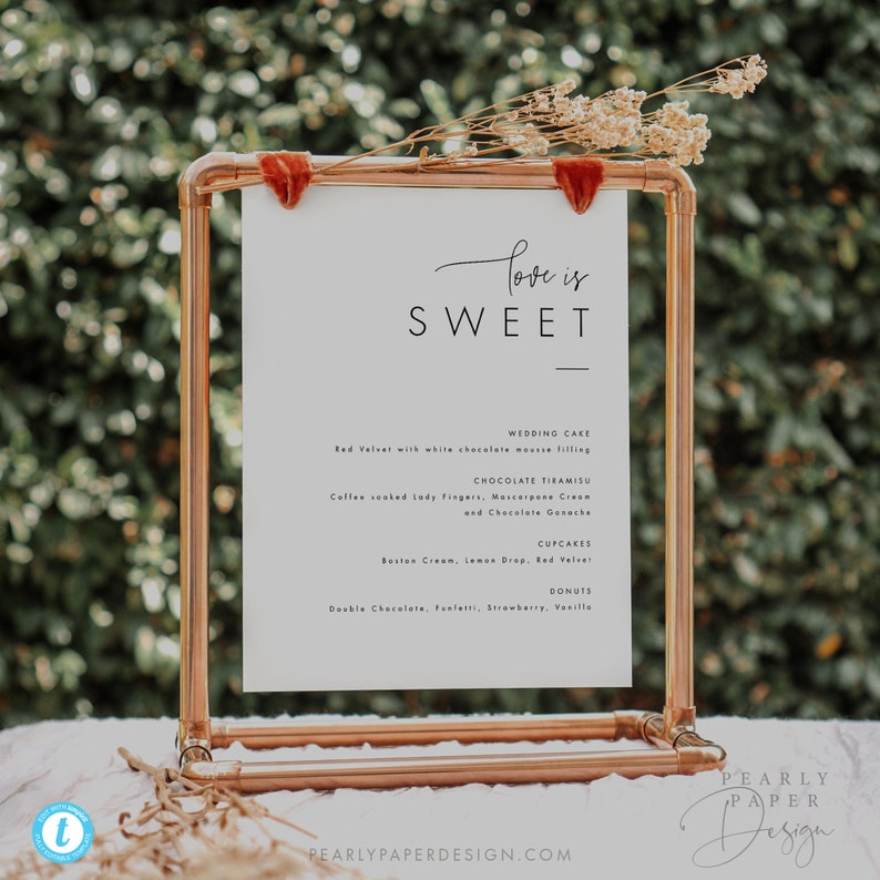 Puede incluir: Un soporte de tuber&iacute;a de cobre con un cartel blanco que dice "Love is Sweet" y enumera la torta de bodas, el tiramis&uacute; de chocolate, los cupcakes y las donas. El cartel est&aacute; decorado con una cinta de terciopelo rojo.