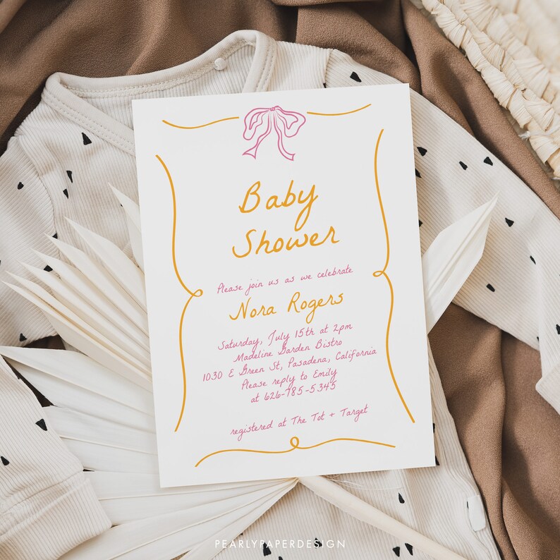 May include: A baby shower invitation with a pink bow and gold lettering. The invitation reads "Baby Shower" and "Please join us as we celebrate Nora Rogers". The event is scheduled for Saturday, July 15th at 2pm at Madeline Barden Bistro in Pasadena, California. The invitation also includes a phone number and registry information.
