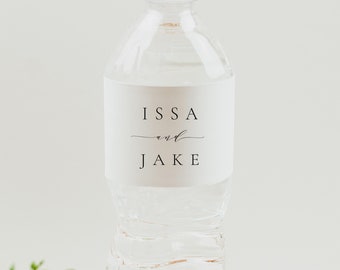 Puede incluir: Una botella de agua blanca con una etiqueta personalizada que dice "ISSA and JAKE" en texto negro.