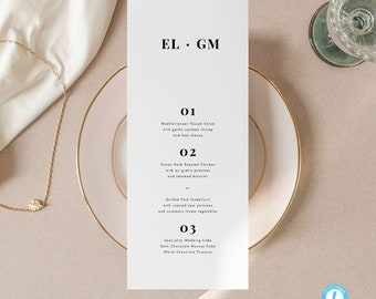 May include: A white wedding menu card with gold trim. The menu card has the text "EL GM" at the top and lists three dinner options: Mediterranean Tossed Salad, Honey Herb Roasted Chicken, and Grilled Pork Tenderloin. The menu card also includes a dessert option: Speciality Wedding Cake.