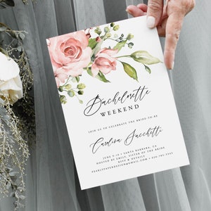 May include: A white invitation card with the text "Bachelorette Weekend" in elegant script, adorned with watercolor roses and greenery. The card includes details for the event, including the bride's name, date, and location.