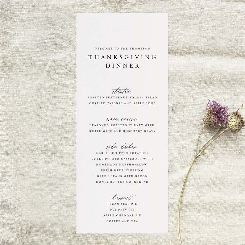 May include: A Thanksgiving dinner menu with a handwritten font. The menu includes appetizers, main course, side dishes, and dessert. The menu items include roasted butternut squash salad, seasoned roasted turkey with white wine and rosemary gravy, garlic whipped potatoes, sweet potato casserole with homemade marshmallow, fresh herb stuffing, green beans with bacon, honey butter cornbread, pecan slab pie, pumpkin pie, apple cheddar pie, coffee and tea.