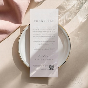May include: A white thank you card with a marble texture background. The text "Thank You" is in a black font at the top of the card. The text "Dear Family and Friends" is in a black font below the "Thank You" text. The text continues with a message of gratitude for the guests attending the wedding. The text "Lots of Love" is in a cursive font with the names "Ellie & James" below it. A QR code is at the bottom of the card with the text "We would love to see our special day through your eyes. Please scan to share your photos and videos with us."