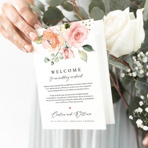 Peut inclure: Une pancarte de bienvenue pour un week-end de mariage avec un motif floral dans des tons de rose et de p&ecirc;che. Le texte indique "Bienvenue &agrave; notre week-end de mariage" et comprend les noms "Carlien et William" ainsi que la date "29-31 mai 2020". La pancarte indique &eacute;galement le lieu "Beaulieu Gardens".
