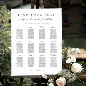 May include: A white seating chart with black text for a wedding reception. The chart is titled "Find Your Seat" and lists the names of guests for each table. The tables are numbered one through twelve. The wedding couple's names are "Alexandre and Jonathan" and the date is September 2017. The text at the bottom of the chart reads "#ALEXHEARTSJON".