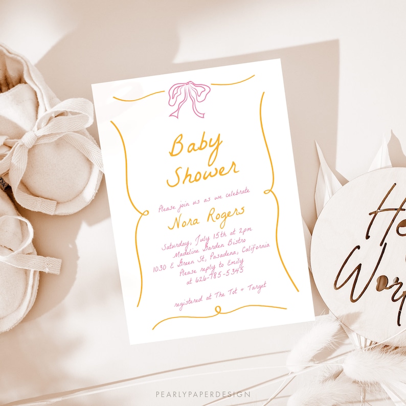 May include: A white baby shower invitation with a pink bow and gold lettering. The invitation reads "Baby Shower" and "Please join us as we celebrate Nora Rogers". The invitation also includes the date, time, location, and RSVP information.