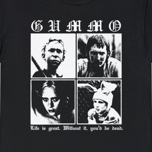 May include: Black t-shirt with a white graphic print of four faces in squares. The text "GU M M O" is above the faces and the text "Life is great. Without it, you'd be dead." is below the faces.