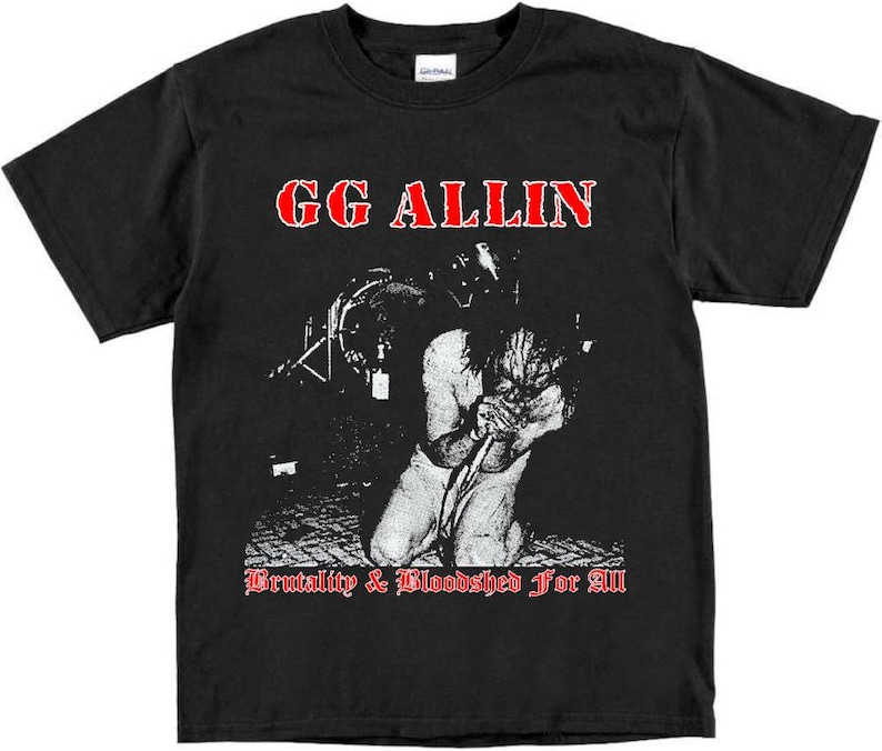 May include: Black t-shirt with a white image of GG Allin, a musician, performing on stage. The text "GG Allin" is in red letters above the image. The text " Brutality & Bloodshed For All" is in red letters below the image.