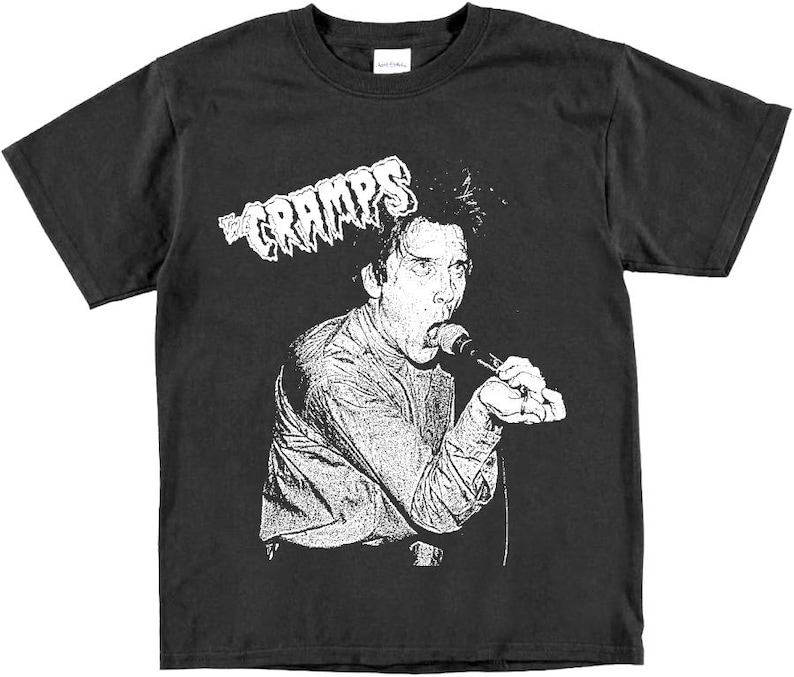May include: Black t-shirt with a white graphic of a person singing into a microphone with the text "The Cramps" above.