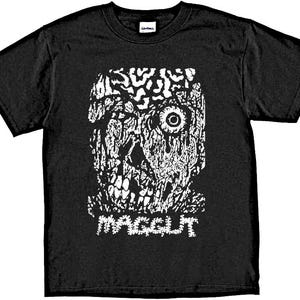 May include: Black t-shirt with a white graphic print of a skull with a single eye and the word "MAGGOT" underneath.