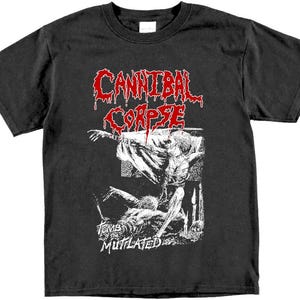 May include: Black t-shirt with a white graphic of a band called "Cannibal Corpse". The graphic features a bloody, distorted figure with the text "Tomb Mutilated" below.