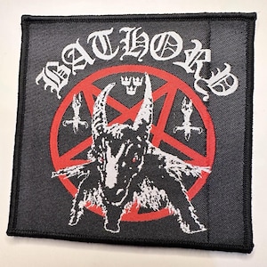 May include: Square black patch featuring the word "BATHORY" in white gothic lettering above a red pentagram. Inside the pentagram is a black illustration of a goat-like figure with red eyes. The patch has a black border.