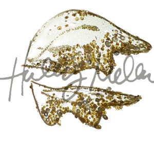May include: A pair of gold glitter wings with a white background. The wings are made of a sheer fabric with gold glitter sprinkled on top. The wings are in a spread position, with the tips of the wings pointing outwards.