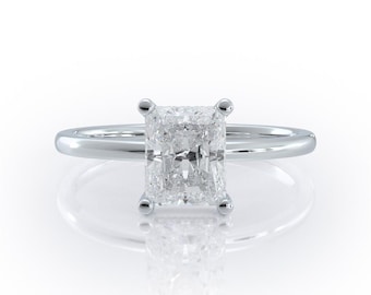 May include: A silver engagement ring with a large, clear, square-shaped diamond.