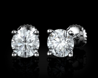 May include: A pair of silver stud earrings with round, clear, sparkling diamonds.