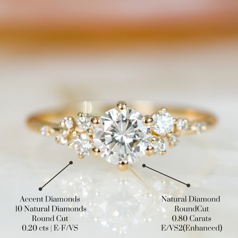 May include: A gold engagement ring with a large round center diamond and smaller accent diamonds. The center diamond is 0.80 carats and is E/VS2(Enhanced). The accent diamonds are 0.20 carats and are E-F/VS.