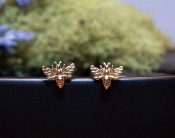 Op de afbeelding: Een paar gouden bijen oorbel studs. De oorbellen zijn klein en delicaat, en ze zijn perfect om een vleugje whimsy toe te voegen aan elke outfit.
