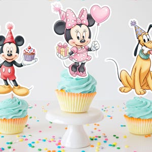 May include: Three cupcakes with blue icing and character toppers. Mickey Mouse holds a blue balloon and a cupcake. Minnie Mouse holds a pink heart balloon and a gift. Pluto holds a bone. Colourful sprinkles are scattered around.