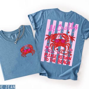 K&ouml;nnte beinhalten: Zwei blaue Jeans-T-Shirts mit Krabbenmotiven. Ein Shirt hat ein kleines Krabbenmotiv auf der Vorderseite. Das andere Shirt hat ein gr&ouml;&szlig;eres Krabbenmotiv auf der R&uuml;ckseite mit dem Text "If Crabby Please Return to the Beach."