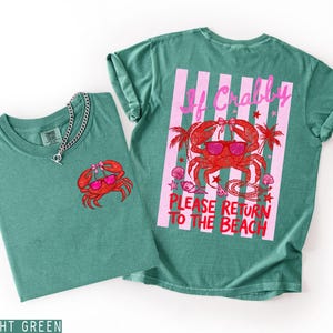 K&ouml;nnte beinhalten: Zwei hellgr&uuml;ne T-Shirts. Eines hat eine kleine Krabben-Grafik mit Sonnenbrille. Das andere hat eine gro&szlig;e Krabben-Grafik mit Sonnenbrille, Palmen und dem Text "If Crabby Please Return To The Beach."
