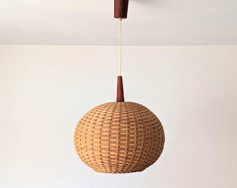 May include: A spherical pendant light fixture featuring a woven tan wicker shade. The light is suspended by a thin cord connected to a dark brown wooden ceiling canopy and a matching dark brown wooden accent piece at the top of the wicker sphere.