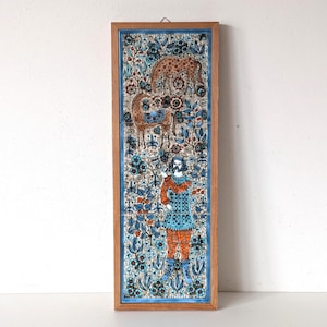 Può includere: Piastrella in ceramica rettangolare incorniciata con un'illustrazione dettagliata e colorata. L'opera presenta un uomo, una giraffa e un leopardo su uno sfondo floreale. La cornice è in legno marrone chiaro e la piastrella ha un bordo blu.