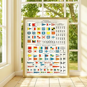 Peut inclure: Tableau encadré de drapeaux nautiques vintage avec un cadre doré. Le tableau affiche divers drapeaux et symboles colorés utilisés pour la communication maritime internationale. Le tableau est placé devant une fenêtre.