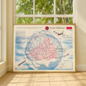 May include: A framed vintage map titled "Concept of Deterrence" with a gold frame. The map depicts a globe with flight paths and illustrations of aircraft and missiles. The color palette includes blue, pink, and red.