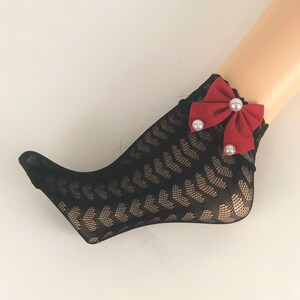May include: Black fishnet socks with a red bow and pearl embellishments.