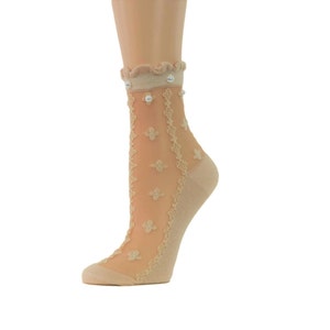 May include: Beige sheer ankle socks with a delicate floral pattern and pearl embellishments. The socks have a scalloped edge at the top.