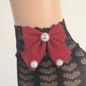 May include: Black lace ankle socks with a red bow and pearl embellishments.