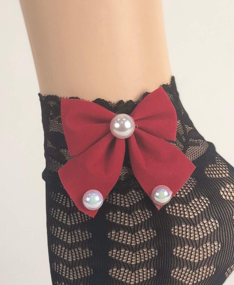 May include: Black lace ankle socks with a red bow and pearl embellishments.