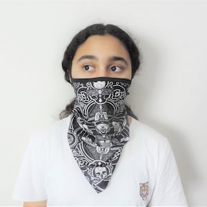 May include: A black and white patterned face covering with a button fastening. The mask is made from a soft, breathable fabric and is designed to be comfortable to wear.