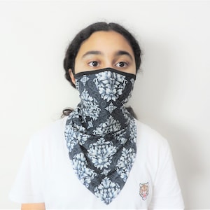 May include: A black and white patterned face covering with a floral design. The mask is made of a soft, breathable fabric and is designed to cover the nose and mouth.