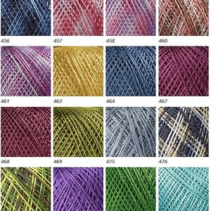 May include: A collection of 12 skeins of metallic yarn in various colors, including blue, pink, gold, green, purple, and silver. Each skein is wound into a ball shape and has a label with a number.