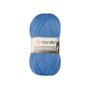 May include: A ball of YarnArt Angora de Luxe yarn in a light blue color. The label reads "YarnArt Angora de Luxe".