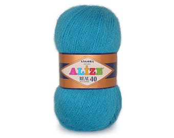May include: A skein of teal blue yarn labeled "Alize Real 40" Angora. The yarn is soft and fluffy, perfect for knitting or crocheting.