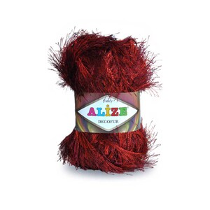 May include: A skein of red yarn with a fluffy texture. The yarn is labeled "Alize Decofur Fancy".