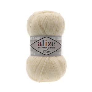 May include: A skein of Alize Angora Gold Star yarn in a cream color with gold glitter. The yarn is wrapped around a cardboard tube with a label that reads "Alize Angora Gold Star".