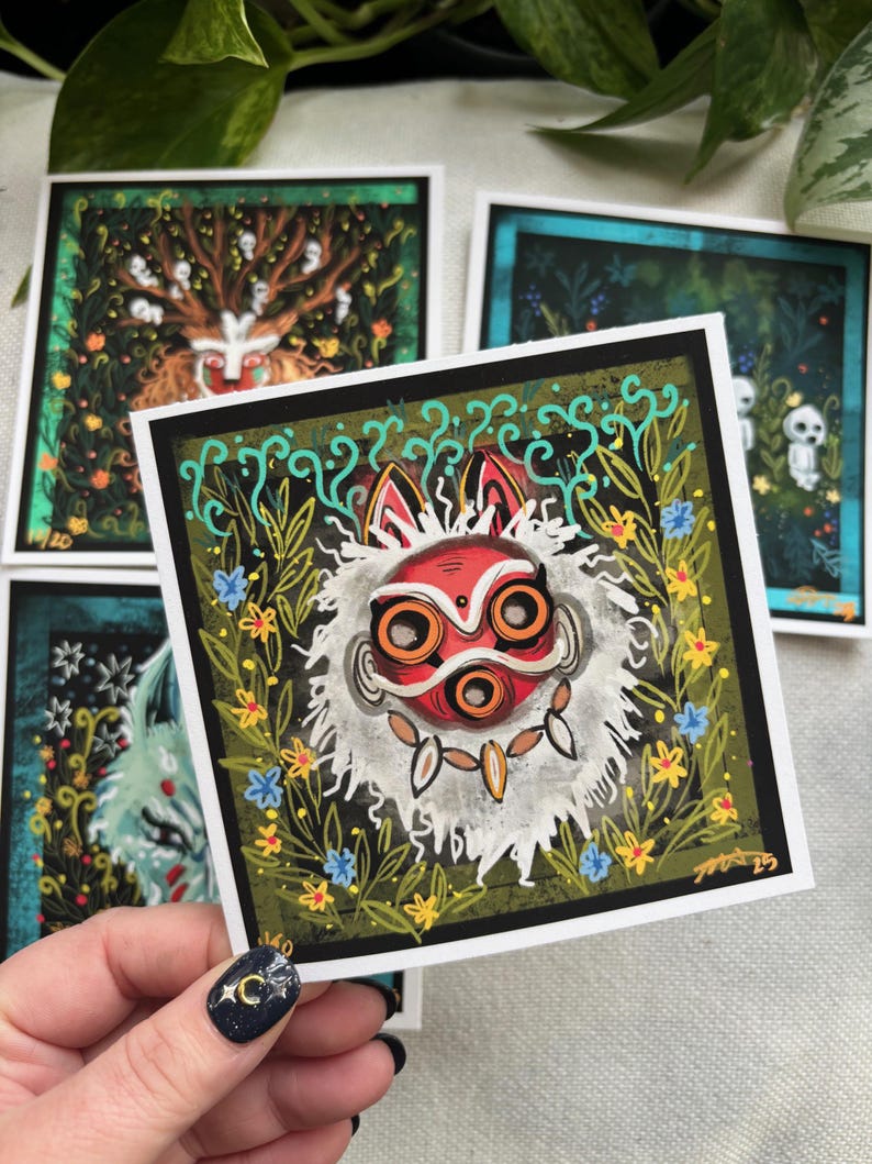 Puede incluir: Un conjunto de cuatro tarjetas ilustradas que presentan una m&aacute;scara roja y blanca con ojos naranjas, un &aacute;rbol con figuras blancas, una escena de bosque azul y verde y una figura blanca con un halo azul. Las tarjetas est&aacute;n impresas en papel blanco con bordes negros.