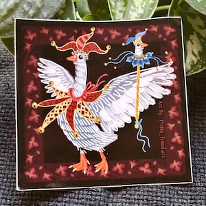 May include: A sticker featuring a whimsical illustration of a goose dressed as a jester. The goose is adorned with a red, gold, and white jester hat and collar, with a matching outfit. The background is dark with a floral border. Text reads "Art By: Pretty_Familiars."