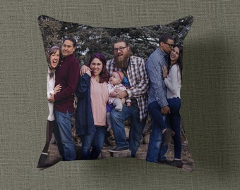 May include: A family of six pose for a photograph in a wooded area. The family includes two adults, three children, and a baby. The adults are wearing casual clothing, and the children are wearing a variety of clothing. The family are standing in front of a tree, and the background is a forest.