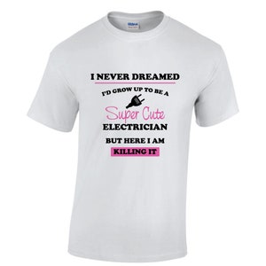 Peut inclure: T-shirt blanc avec du texte noir qui dit "Je n'ai jamais rêvé de devenir un électricien super mignon, mais me voilà, je déchire". Le texte est entouré d'une ligne noire. Une icône de prise rose est au-dessus du mot "mignon".