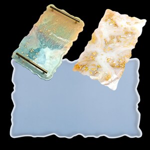 May include: A light blue silicone mold with a wavy edge. Two resin trays are shown, one with a light blue and gold design and the other with a white and gold design.