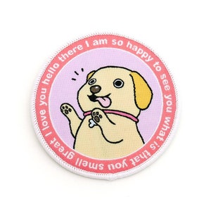 May include: A pink and white embroidered patch with a cartoon dog. The dog is yellow with a pink collar and is holding a bone. The text around the dog reads: "I love you hello there I am so happy to see you what is that you smell great."