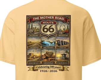 Op de afbeelding: Lichtgeel t-shirt met een Route 66-afbeelding. Het ontwerp bevat de woorden "THE MOTHER ROAD" en "ROUTE 66", plus afbeeldingen die staten langs de route vertegenwoordigen. De tekst "Celebrating 100 years! 1926-2026" is ook zichtbaar.