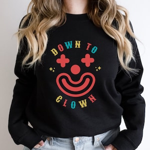 May include: Black sweatshirt with a colorful graphic design that says "Down to Clown" with a stylized clown face.